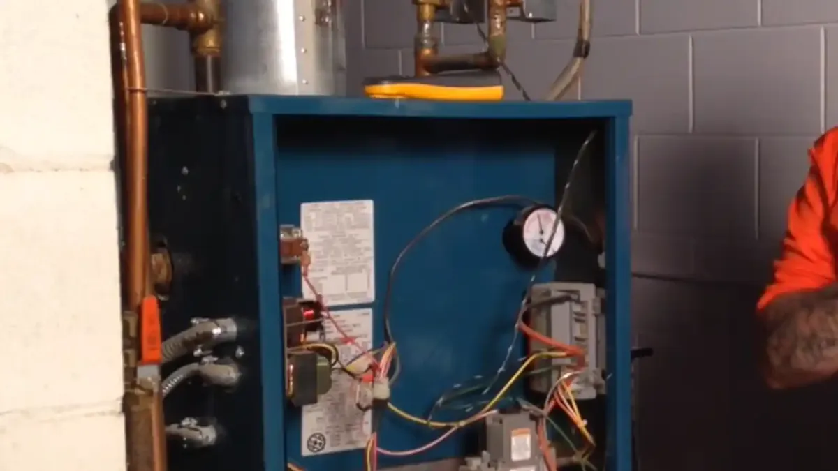 Boiler cabinet with gauge, wiring and copper piping in a basement
