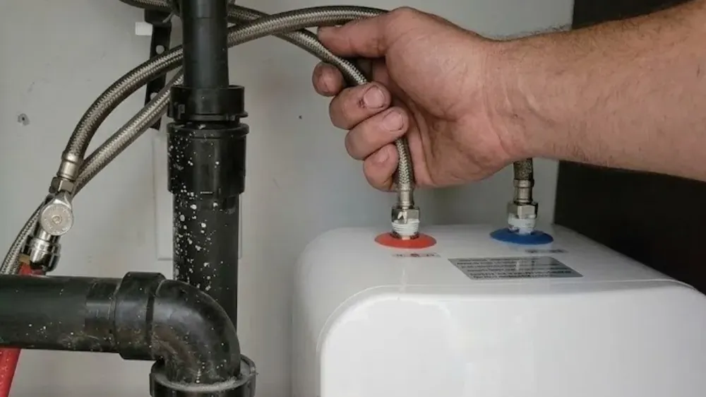 Small point-of-use water heater under a sink with flexible supply lines