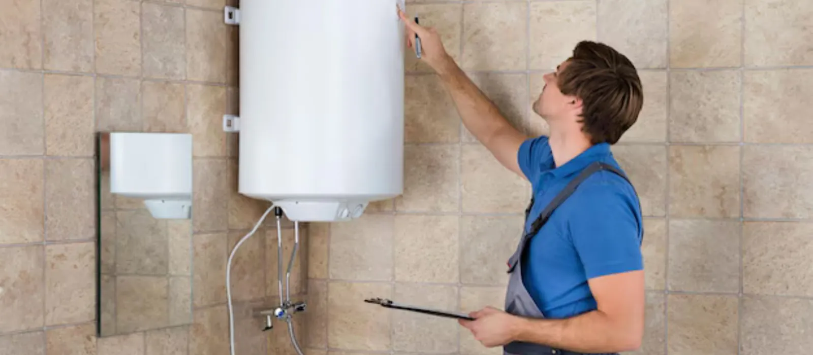 Technician checking a wall-mounted water heater against a tiled wall